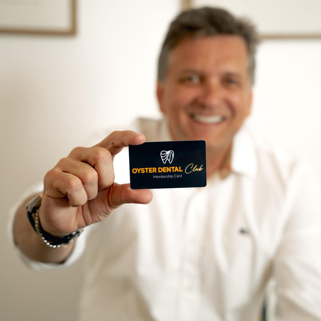 Paciente segurando o cartão Oyster Dental Club